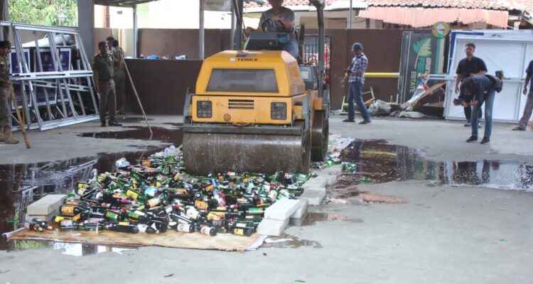 Ribuan Botol Miras Dimusnahkan Menggunakan Alat Berat.