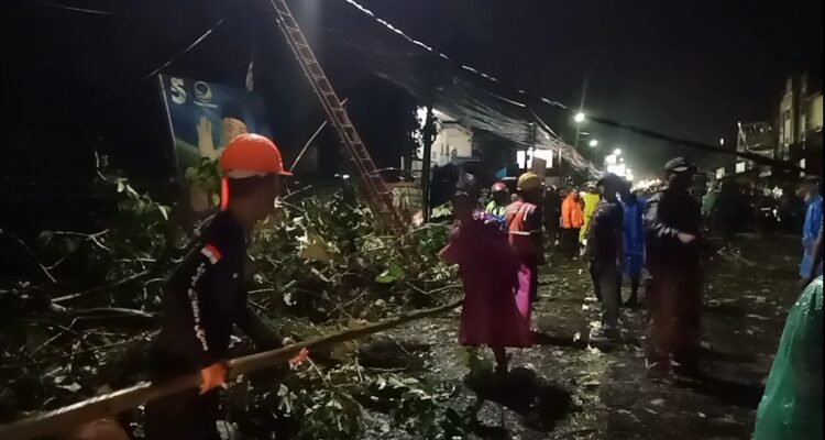 Tim Gabungan SAR Melakukan Evakuasi Pohon Tumbang Yang Menimpa Mobil Avanza di Jalan Raya Tajur