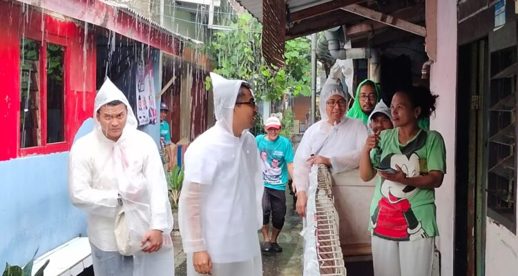 Calon wakil wali kota Bogor nomor urur 5, Eka Maulana saat melakukan blusukan memakai jas hujan