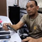 Seorang petugas kepolisian dari Polsek Cileungsi duduk di meja sambil memeriksa barang bukti berupa senjata tajam dan beberapa unit ponsel yang diduga hasil kejahatan, di ruang pemeriksaan dengan latar belakang logo Humas Polsek Cileungsi.