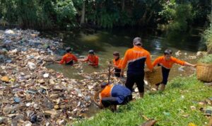 Petugas DLH Kabupaten Bogor saat membersihkan sampah di sungai, Foto/Istimewa
