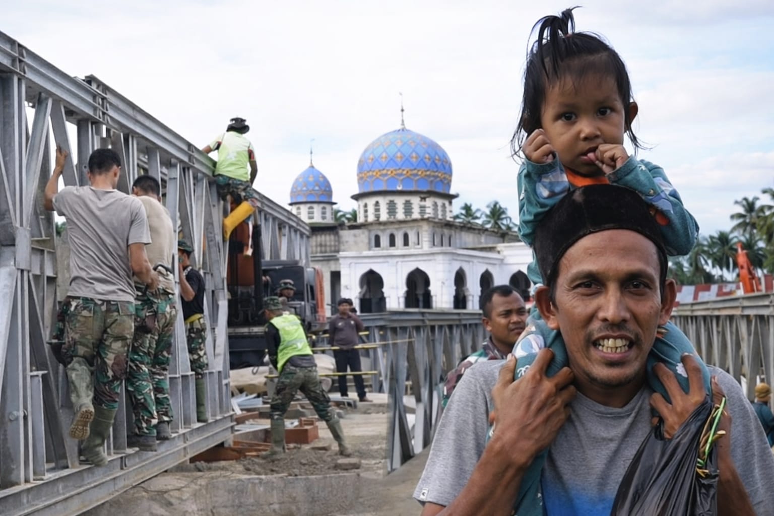 Seorang warga yang menggendong anak Jembatan Teupin Mane yang menjadi akses penghubung dari Kabupaten Bireuen ke wilayah tengah atau pegunungan Aceh,Foto/Istimewa
