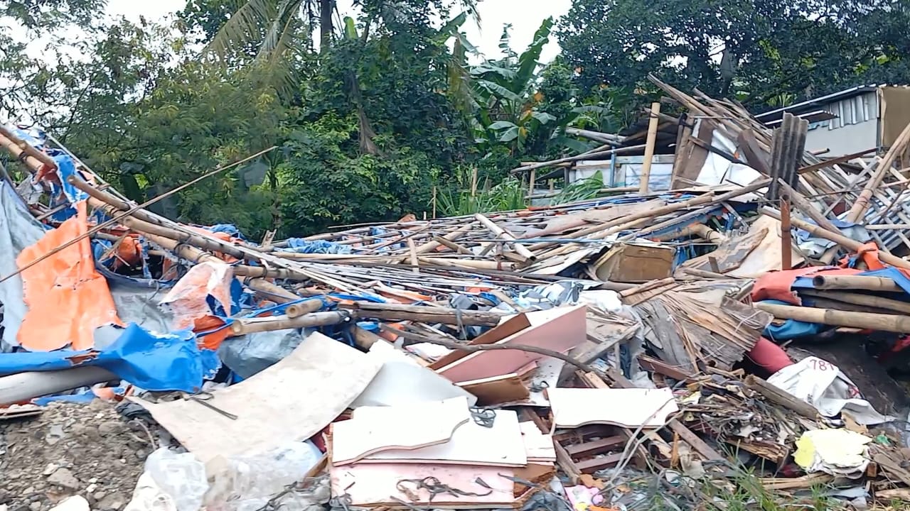 Puing-puing bangunan liar yang dibongkar Satpol PP terlihat menumpuk di Jalan Raya Cipayung, Depok, pada Kamis (20/11).