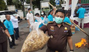 Salah satu anggota Kejari Bogor memegang keripik pisang yang duga bernarkoba, Foto/Istimewa