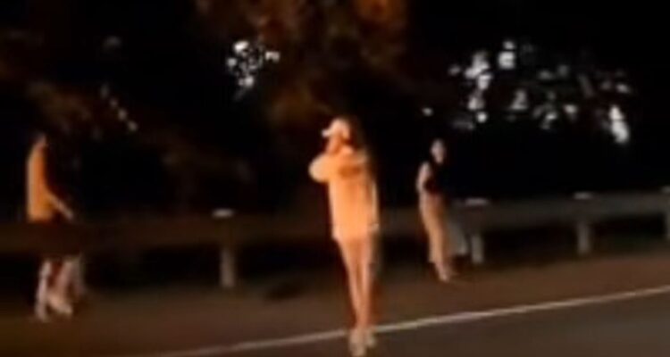 seorang wanita berinisial IR (23) keluar dari mobil dalam kondisi panik setelah kendaraannya terbakar, Foto/SS Video