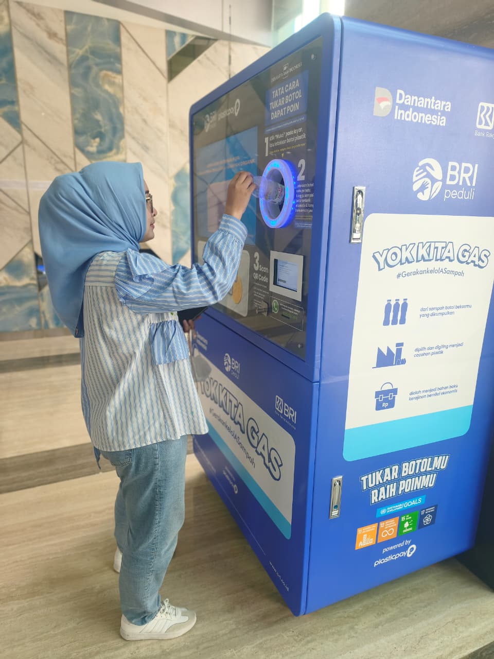 Nasabah BRI saat menggunakan Menara BRILiaN memiliki mesin daur ulang botol plastik, Foto/Istimewa